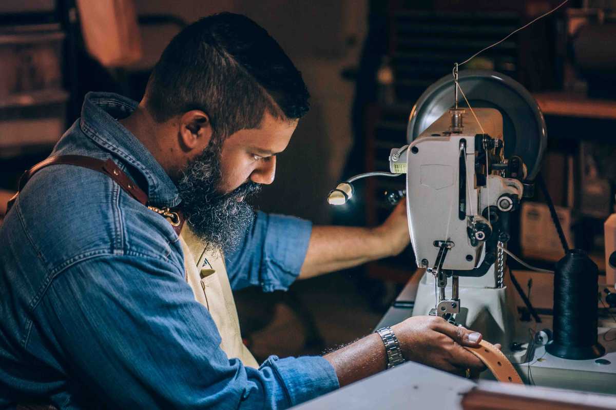 Male leatherworker making belt